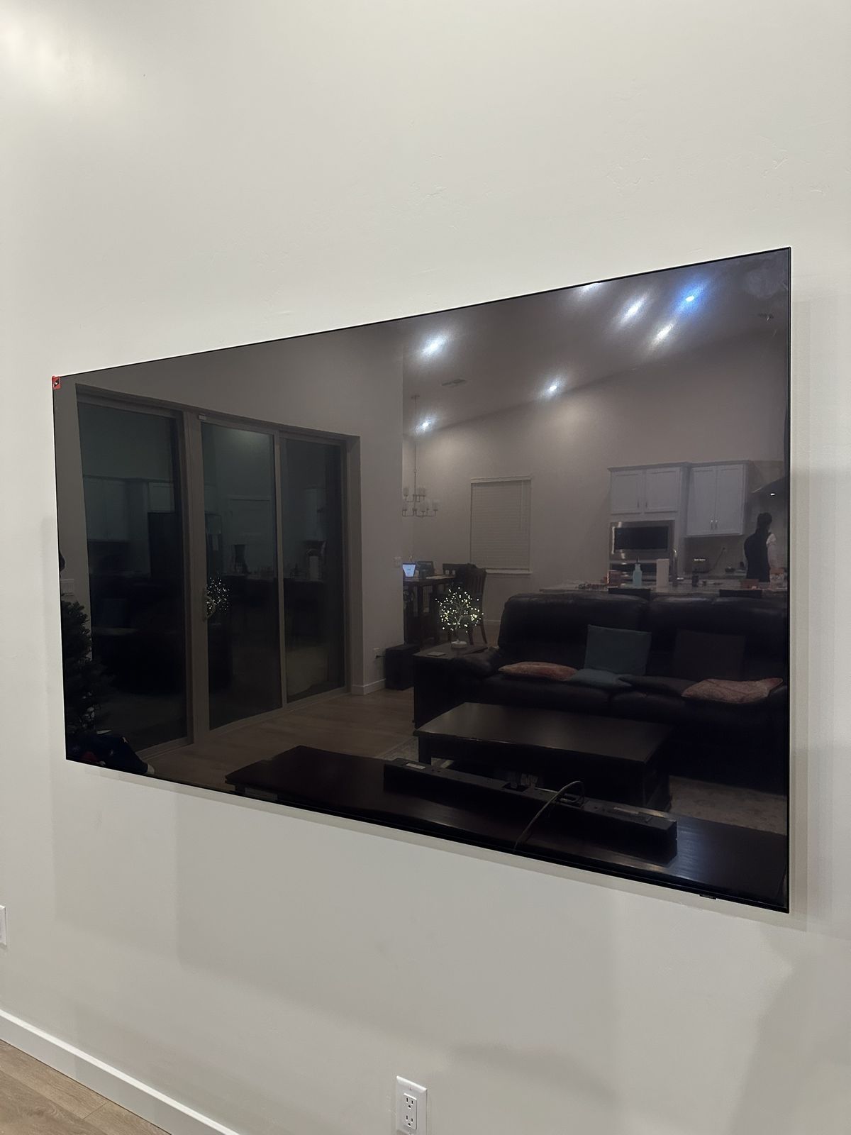 Large TV mounted tight to a white wall with no cords showing